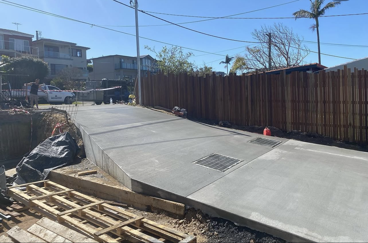 Completed concrete driveway and vehicular crossing with drainage grates