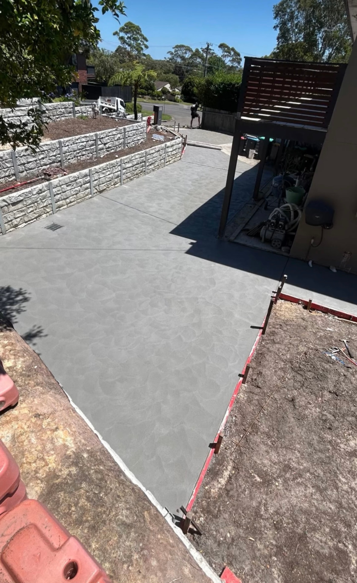 Concrete patio and entertaining area beside a retaining wall